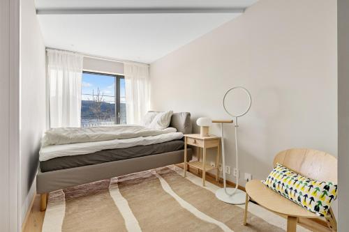 1 dormitorio con 1 cama, 1 silla y 1 ventana en Amazing View - 5 bedrooms - new house - modern and exclusive, en Bergen