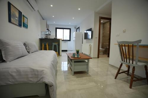 a bedroom with a bed and a table and a chair at Le gris Ciel in Sfax