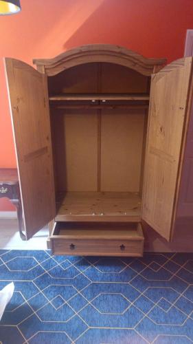 a wooden cabinet sitting on top of a room at L'Auberge close Syon Lane Station and Heathrow in London