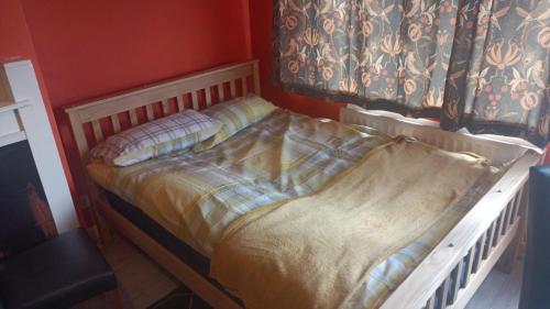 a bed in a room with a red wall at L'Auberge close Syon Lane Station and Heathrow in London