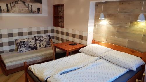 a bedroom with two beds and a table in it at Przy Bulwarze in Mielno