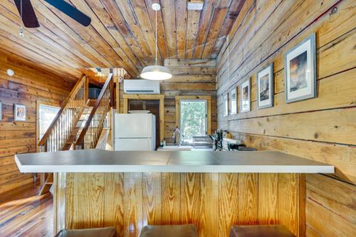 a room with wooden walls and a counter with chairs at The Bird House Lush Bungalow, Steps from Ocean! in Folly Beach