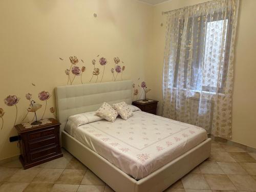 a bedroom with a bed with flowers on the wall at Casa d amare in Gioiosa Marea