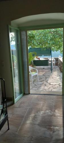 an open door to a patio with a table and chairs at MELPO in Évyiros