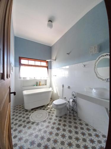 een badkamer met een bad, een toilet en een wastafel bij SÍTIO VALE DO RIO VERDE in Pouso Alto