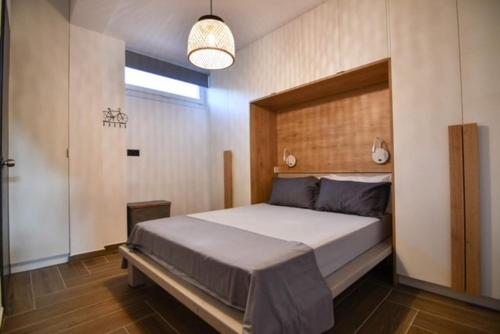 een slaapkamer met een groot bed met een houten hoofdeinde bij Passatempo Apartment Ireon in Samos