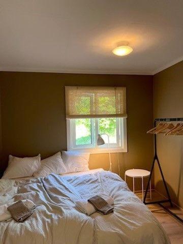 a bedroom with a white bed and a window at Solstad fritidsbolig in Hjelle