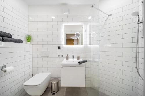 a white bathroom with a sink and a toilet at Internesto Brno Krenova in Brno