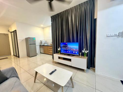 een woonkamer met een flatscreen-tv op een tafel bij ITCC Manhattan Suites by AURORA in Penampang