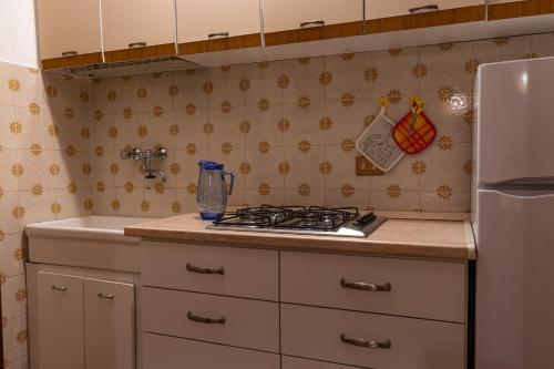 a kitchen with a stove top oven next to a sink at Sunset House - Casa al Tramonto in Selva di Progno