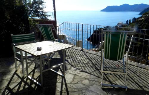 a table and chairs on a balcony with a view of the ocean at ARIA DI MARE, Manarola - Camere con vista mare! in Manarola