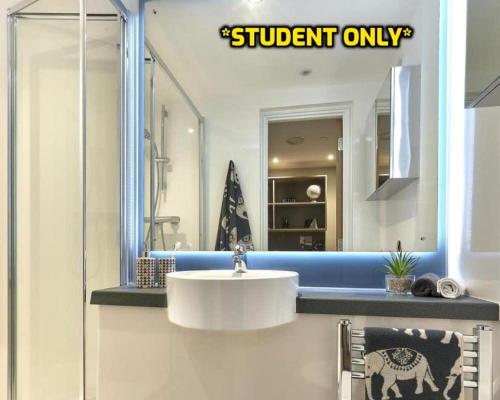 ein Badezimmer mit einem weißen Waschbecken und einem Spiegel in der Unterkunft Student Only Zeni Ensuite Rooms, Southampton in Southampton
