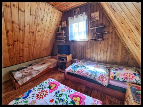 a bedroom with two beds in a wooden cabin at Noclegi u Marka in Czernichów