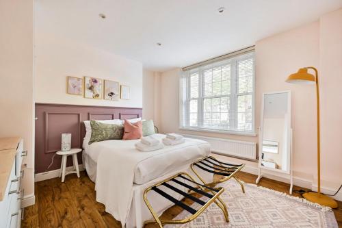 una camera con un letto e una sedia di GuestReady - Classy haven near Camden Town a Londra