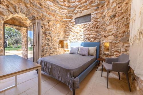 ein Schlafzimmer mit einem Bett und einer Steinmauer in der Unterkunft Villa Platino in Torre Vado