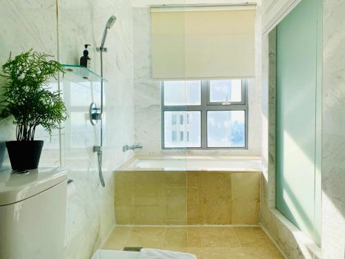 een badkamer met een douche, een toilet en een raam bij Vesta Home @ Silverscape Residence Melaka in Melaka