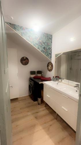 une salle de bain avec un lavabo et un miroir dans l'établissement Appartement privé « Blue Bridge & Sauna », à Serrières