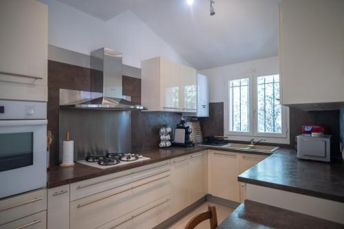a kitchen with white cabinets and a stove top oven at GuestReady - Peaceful Retreat in Antibes in Antibes