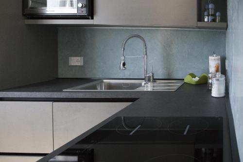 eine Küchentheke mit einer Spüle und einer Mikrowelle in der Unterkunft Villa Platino in Torre Vado