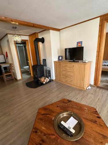 a living room with a television and a table with a remote control at Wetterhorn in Grindelwald