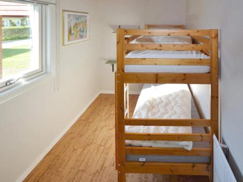 Etagenbett in einem Zimmer mit Fenster in der Unterkunft Holiday home LAHOLM XV in Laholm