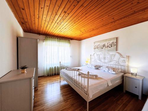ein Schlafzimmer mit einem großen Bett und einer Holzdecke in der Unterkunft Apartments Vilma in Murter