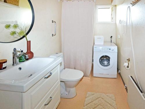 ein Badezimmer mit einem WC und einer Waschmaschine in der Unterkunft Holiday home LAHOLM XIV in Laholm