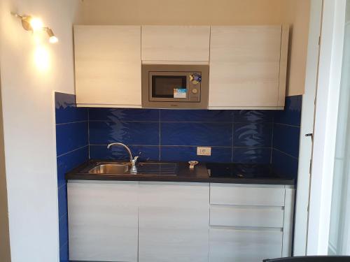a small kitchen with a sink and a microwave at Casa Acqua Marina Le Forna in Ponza