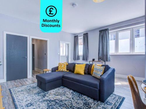 a living room with a blue couch and yellow pillows at Spacious and Modern 1 Bed 1 Bath Apartment in the Heart of Eastbourne in Eastbourne