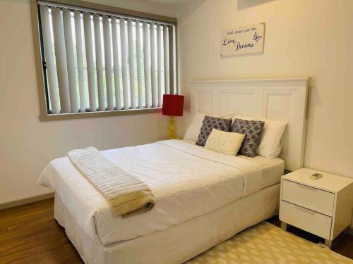 a bedroom with a large white bed with a window at D104 Winston Fresh Fantastic in Braybrook