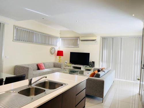 a kitchen and living room with a couch and a sink at D104 Winston Fresh Fantastic in Braybrook