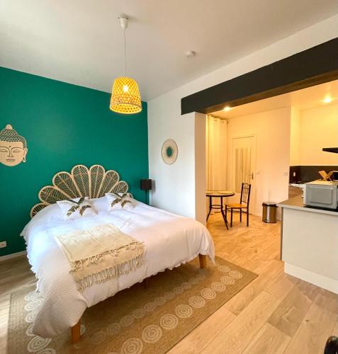 une chambre avec un lit et un mur végétal dans l'établissement Le Balinais - Centre-ville, à Melun