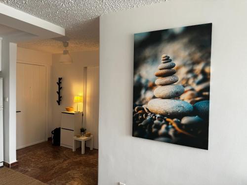 a painting of a stack of rocks on a wall at Seashore Happiness Apartments in Porto Rafti