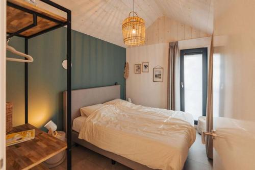 una camera con letto e lampadario a braccio di Kos I Tiny house met grote tuin a Epe