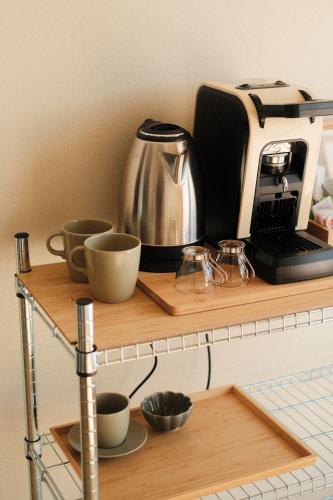 a coffee maker and coffee cups on a shelf at Famiglia Scirocco Guest House in Offida