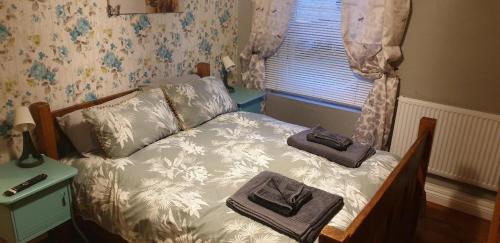a small bed in a room with a window at Cosy 3-Bed House in Kidwelly in Kidwelly