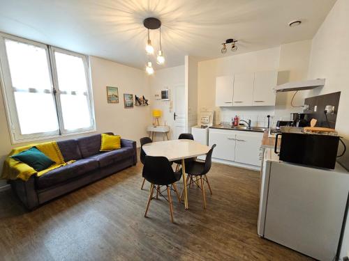 a living room with a couch and a table at T2 Ctre ville Fibre Literie Emma in Montrichard