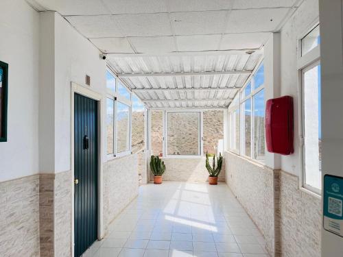 einen Flur in einem Gebäude mit Fenstern und Tür in der Unterkunft Corona Amarilla Sea View and Relax Puerto Rico in Puerto Rico de Gran Canaria