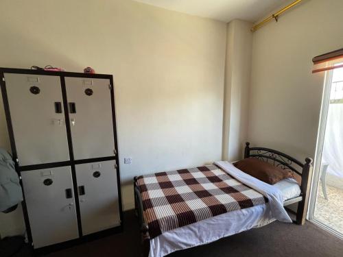 a bedroom with a bed and a dresser in it at Pizza Street Hostel in Aqaba