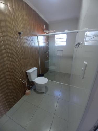 uma casa de banho com um WC e uma cabina de duche em vidro. em POUSADA SÃO LUCAS em Águas de Lindoia