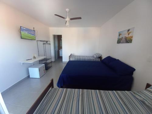 a bedroom with a blue bed and a ceiling fan at POUSADA SÃO LUCAS in Águas de Lindóia