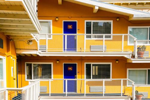 a yellow building with blue doors and white balconies at Hotel Del Sol in San Francisco