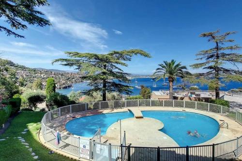 a large swimming pool with a view of the water at Vue baie à 5min de la plage 44m² avec parking in Théoule-sur-Mer