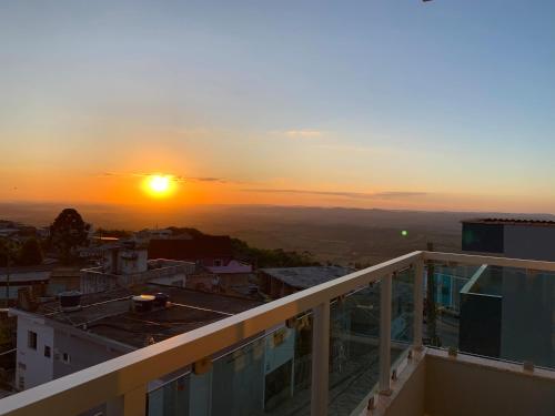 a view of the sunset from the balcony of a building at Pousada Aconchego De São Thomé in São Thomé das Letras