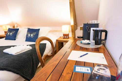 a room with two beds and a wooden table at Château de Tilly in Boissey-le-Châtel
