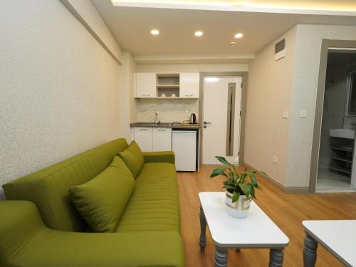 a living room with a green couch and a kitchen at gazelle suites in Istanbul