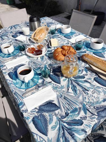 een tafel met een blauw en wit tafelkleed met gebak bij Les Mulotières in Olivet