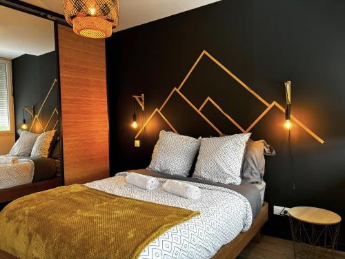 a bedroom with a large bed with a black wall at L'Allégorie - Morbier in Morbier