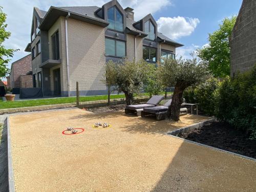a house with a playground in the yard at J and R flanders fields holiday homes in Diksmuide