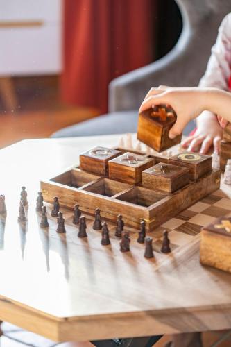 a woman playing chess on a wooden chessboard at Château de Tilly in Boissey-le-Châtel